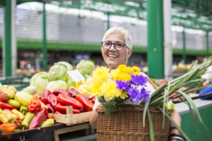 a woman holding flowers at a farmer's market