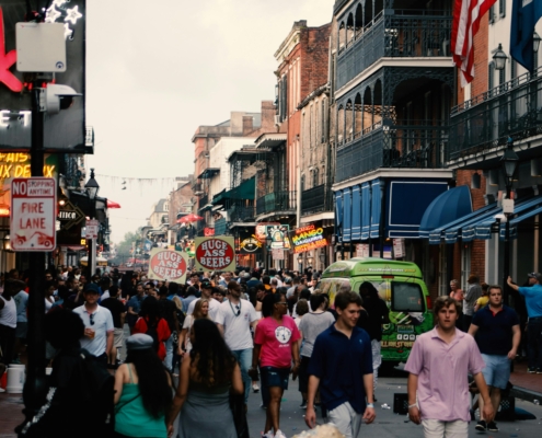 a large crowd of tourists walking down a busy bourbon street in new orleans