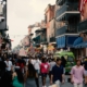 a large crowd of tourists walking down a busy bourbon street in new orleans