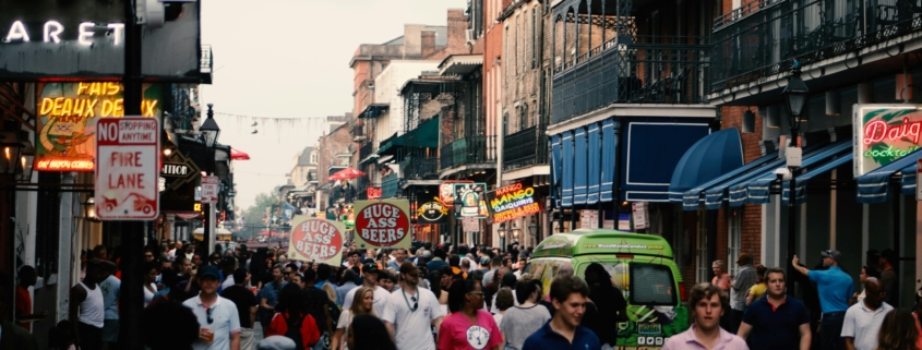 a large crowd of tourists walking down a busy bourbon street in new orleans