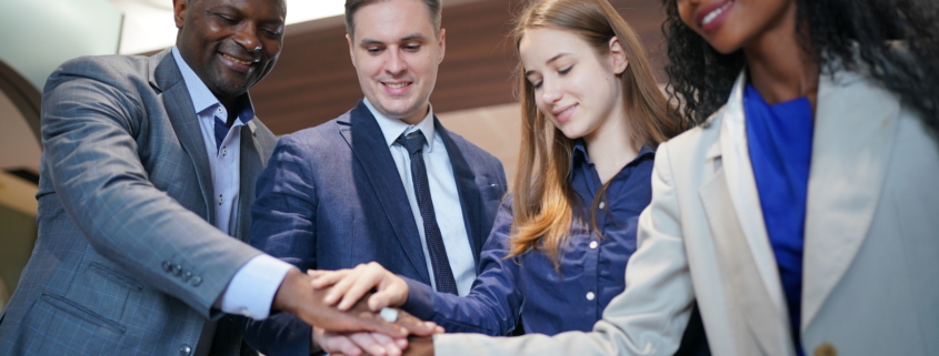 A diverse group coming together as a team during a business meeting